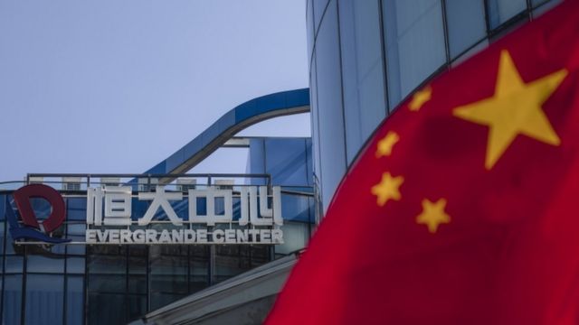 An Evergrande logo and Chinese flag are seen in front of the Evergrande Center in Shanghai, China.