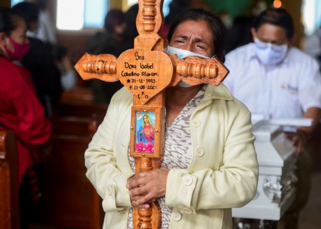 Señora lleva una cruz con el nombre de la mujer fallecida: Dora Isabel.