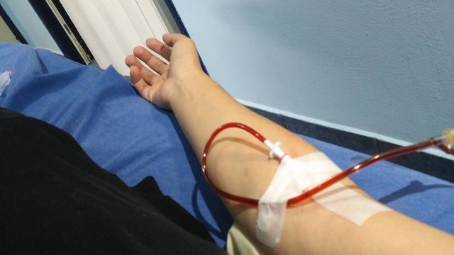 El brazo de Astrid Morales con una vía intravenosa