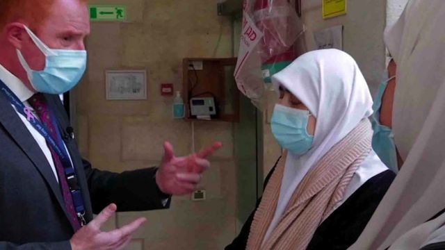 Dr Fadi speaks to two patients wearing masks