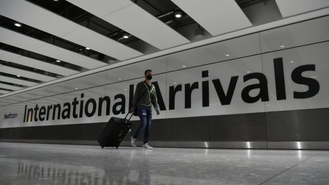 Un hombre con mascarilla llegando a Heathrow.