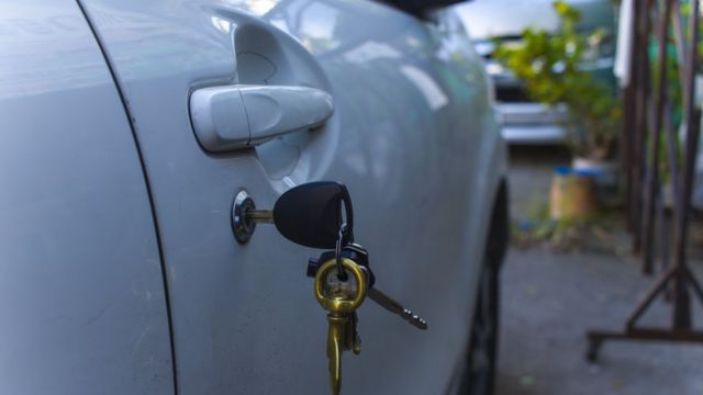 Una puerta de un auto con las llaves puestas.