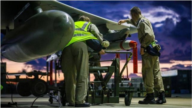 英国皇家空军武器技术人员正为一架英国皇家空军台风FRG4战机进行空袭前准备。