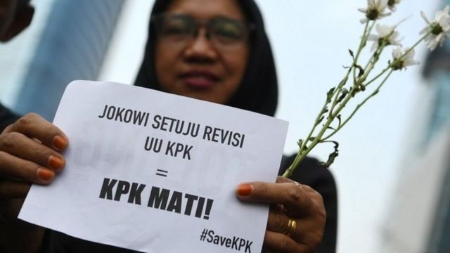 Pegawai KPK membawa bunga dan poster untuk dibagikan kepada warga pada melakukan aksi saat Hari Bebas Kendaraan Bermotor di kawasan Bundaran HI Jakarta, Minggu (8/9).