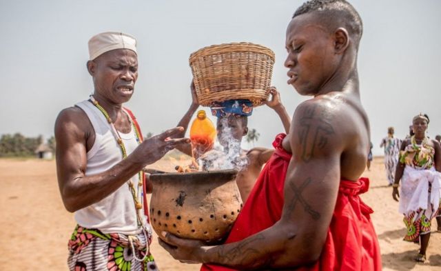 A Voodoo follower holds a fetish during the Voodoo Festival in Ouidah, Benin, on January 10, 2022