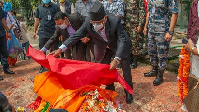 बर्मन बुढालाई पार्टीको झण्डा ओडाउँदै पुष्पकमल दाहाल
