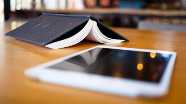 Un libro abierto y una tablet