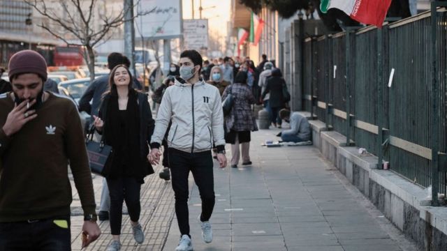 People walk down a street in Tehran, Iran (1 February 2021)