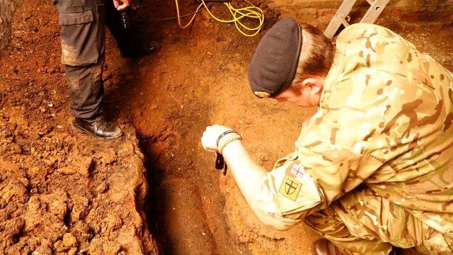 Bomb disposal experts examine the unexploded WW2 bomb