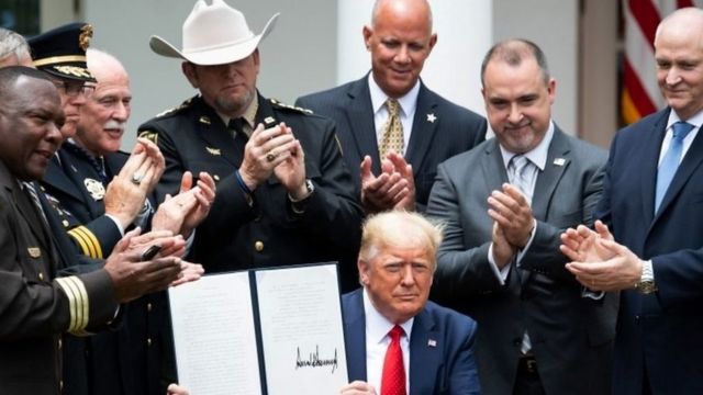 Donald Trump mostrando su orden ejecutiva firmada