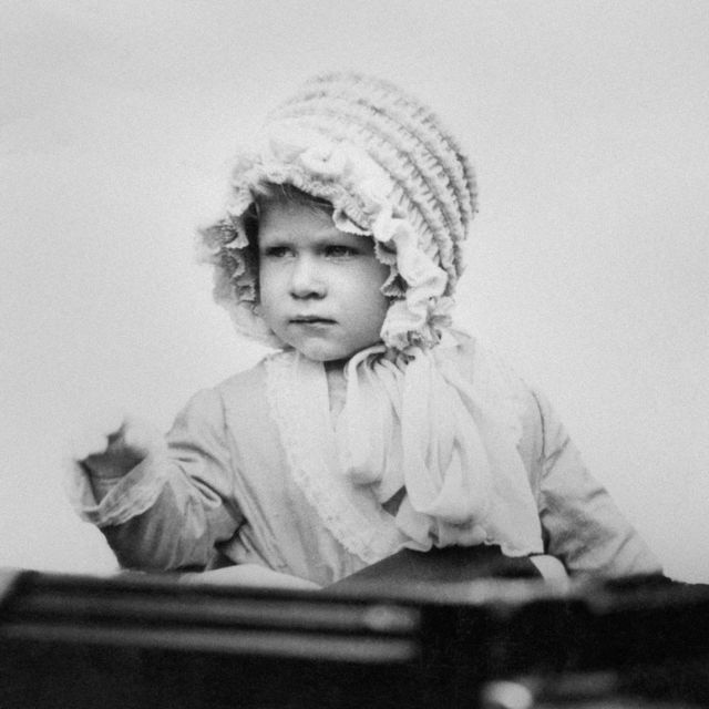 Princess Elizabeth waving from a carriage as she drives in London