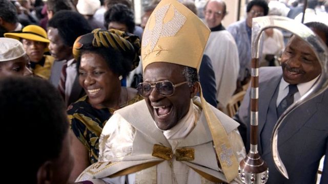 Desmond Tutu smiles after being appointed Anglican Archbishop of Cape Town in 1986, with his wife, Leah, is at his side
