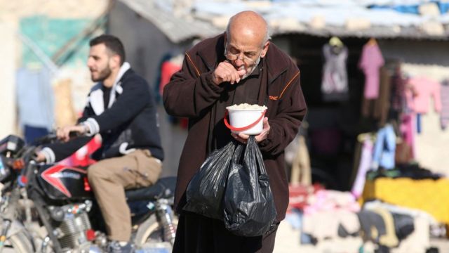 A man eats food that was distributed as aid in a rebel-held, besieged area in Aleppo, Syria (6 November 2016)