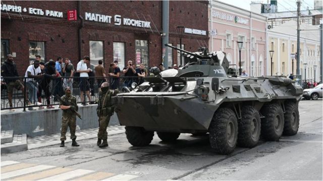 瓦格纳士兵站在顿河畔罗斯托夫一辆装甲车旁边。
