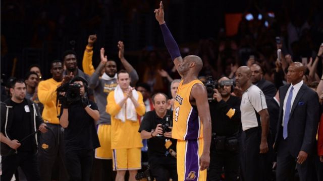 umukinnyi wa Los Angeles Lakers Kobe Bryant (24) apepera abafana muri sitade ya Staples Center nyuma y'umukino bakinaga na Utah Jazz