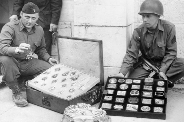 Soldados americanos ao lado de itens roubados por nazistas