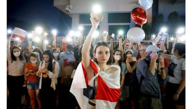 متظاهرة تحمل هاتفها المحمول في مسيرة بعد الانتخابات الرئاسية محل النزاع في بيلاروسيا