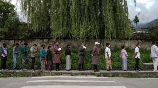 Pessoas fazem fila para se registrar e serem inoculadas com vacina contra Covid-19 em um centro temporário de vacinação em Thimpu