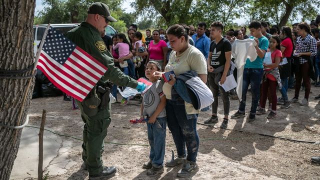 Un agente de frontera de EE.UU. atiende a unos solicitantes de asilo.