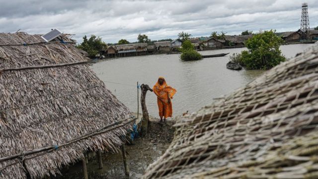 A woman stands in front of her house, which has been reconstructed several times each time a cyclone hits the coastal area of ​​Jaimani village in Bangladesh, which is one of the countries hardest hit by the effects of climate change.