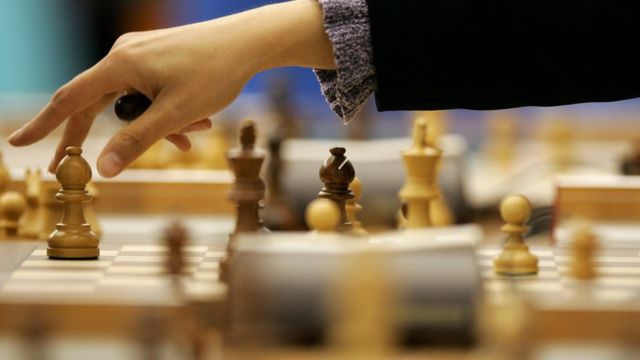 Una mujer jugando ajedrez.