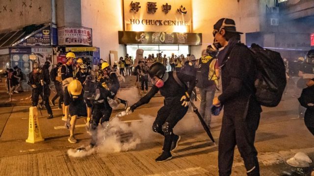Protesters put out the tear gas as they pour water on it at Kwai Fong district