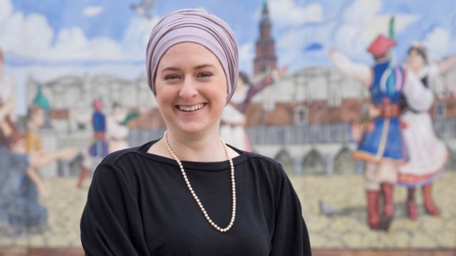 Amanda Jakowski, nowo wybrana członkini zarządu Hamtramck, pozuje przed muralami ku czci polskiego dziedzictwa.