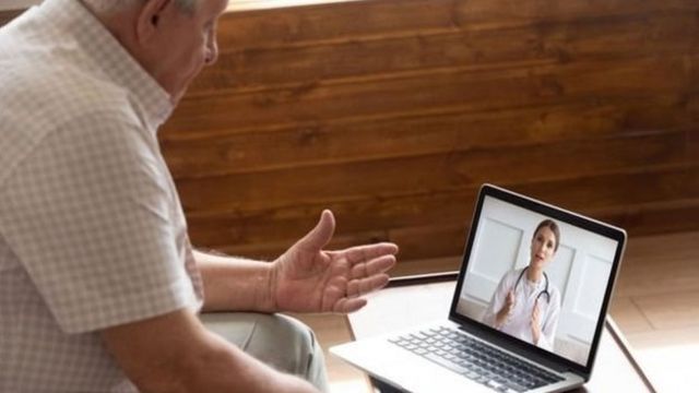 Homem conversando com médica por meio de laptop