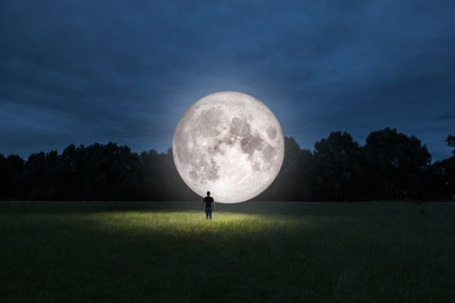 мужчина и изорбажение Луны на поляне