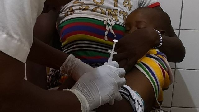 Un niño en los brazos de su madre mientras lo vacunan.