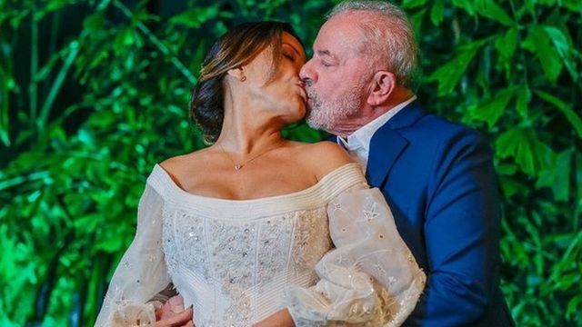 Vestida de noiva, Janja beija Lula, que a abraça por trás