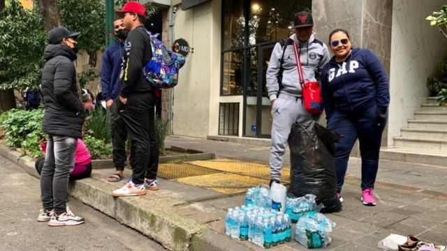 Adriana entregando agua a migrantes frente a la Comar