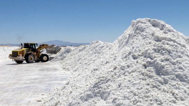 An excavator collects mountains of white lithium.