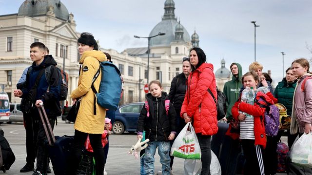 People fleeing the Russian military campaign in eastern Ukraine wait to board a bus that will take them to Poland on 9 April 2022 in Lviv, Ukraine