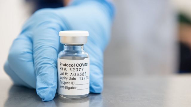 Close-up of the hand of someone holding a vial of the AstraZeneca and Oxford University vaccine