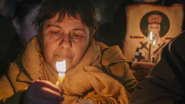 Жена држи упаљену свећу током литије у Подгорици, 16. фебруара