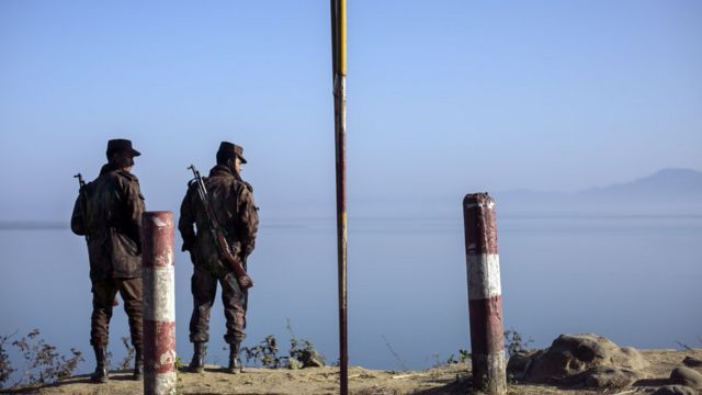 Border guards stand near the edge of the Naf river which separates Myanmar from Bangladesh is seen on February 6, 2017 in Teknaf, Bangladesh