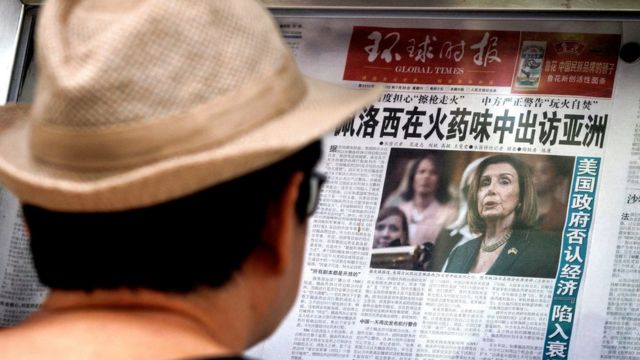 A passerby in a newspaper column in Beijing stopped to read a report by the Chinese Communist Party's Global Times on Pelosi's possible visit to Taiwan (1/8/2022)