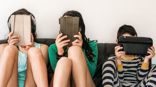 Adolescentes y niños concentrados en sus dispositivos digitales