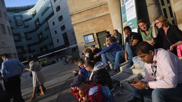 People sat outside the cordon put up outside the BBC