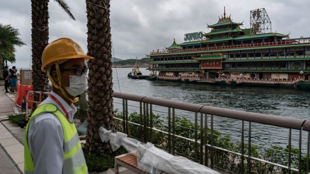 香港仔避风塘海旁一名工作人员在监察珍宝海鲜舫通过出港航道（14/6/2022）