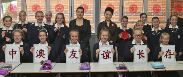 Chinese President Xi Jinpin's wife Madame Peng Liyuan poses for a photo with students during their lessons in Mandarin, calligraphy, paper-cutting and embroidery at Ravenswood School for Girls on November 19, 2014 in Sydney, Australia.
