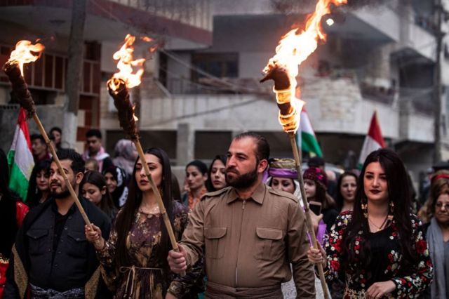أكراد يحملون المشاعل في ليلة نوروز، في مدينة القامشلي، شمال شرقي سوريا
