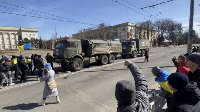 Herson'da üzerinde Z harfi olan Rus askeri araçlarına doğru bağıran protestocular.