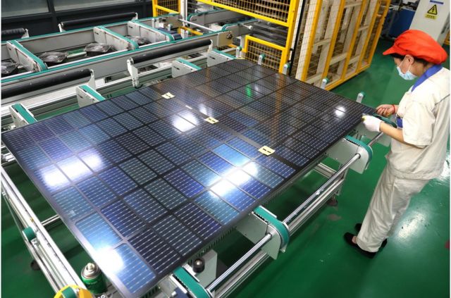 An employee of a company in Lianyungang, China produces solar panels for export in a workshop