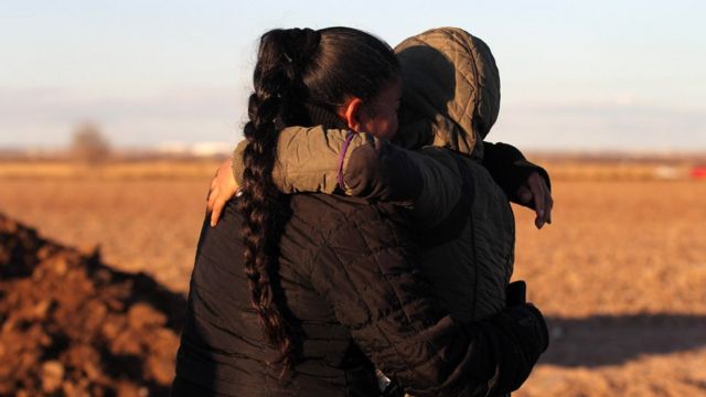 Una mujer y un niño se abrazan cerca de la frontera de México con Estados Unidos.