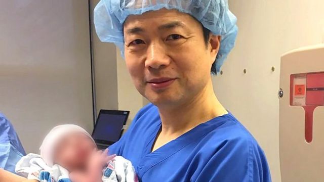 Dr John Zhang holding the baby boy who was conceived thanks to the new technique that incorporates DNA from three people