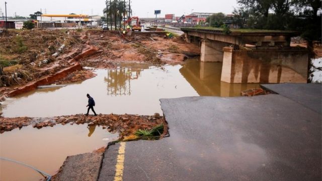 A man walks around a damaged bridge caused by flooding in Umlazi near Durban, South Africa, April 16, 2022