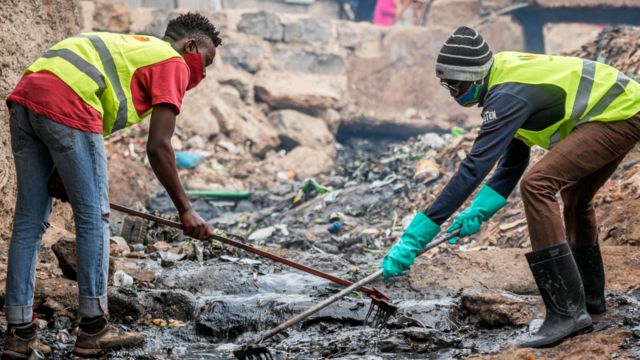 People working as part of government scheme to clear open sewers in Kibera, Kenya