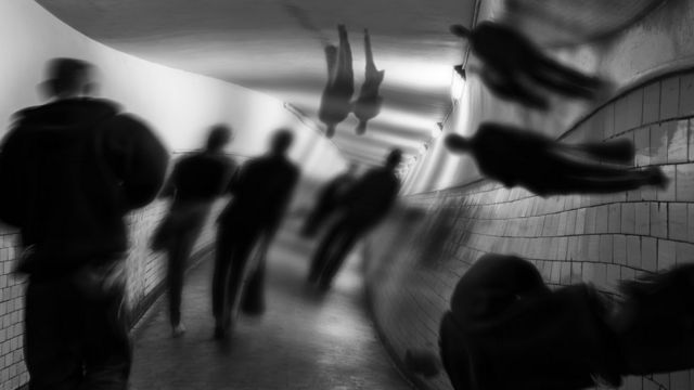 imagen en blanco y negro de personas caminando por un pasillo